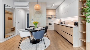 A modern kitchen with a dining area, wooden cabinets, and a central island. - On the Danube, city center, free parking (Bratislava)