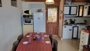 Una cocina compacta con comedor, microondas, tostadora, refrigerador y lavaplatos.