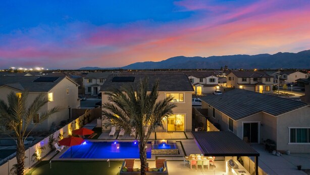 A residential area with modern houses, a swimming pool, and a mountain backdrop. - Eclectic Paradise w/Pool & Spa! Close to Festivals (Coachella)