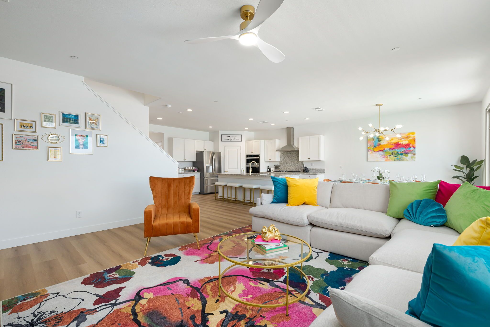 A modern living room with a sofa, coffee table, and a staircase leading to the kitchen.