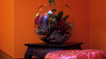 Una stanza con un acquario in vetro trasparente contenente piante e fiori, posato su un supporto in legno.