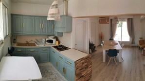 A kitchen with teal cabinets, a wooden island, and a dining area with a table and chairs. - Maison à 5 Minutes de la Plage, la Chicane, Laiguillon sur Mer (L'Aiguillon-la-Presqu'île)