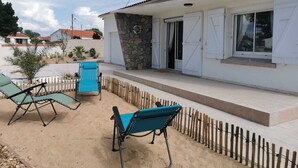 A house with a patio area featuring two blue chairs and a blue cooler. - Maison à 5 Minutes de la Plage, la Chicane, Laiguillon sur Mer (L'Aiguillon-la-Presqu'île)