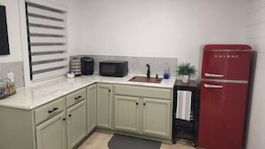 A kitchen with a sink, a microwave, a refrigerator, and cabinets. - Cozy Nook Cottage With Hot Tub (Nevada)