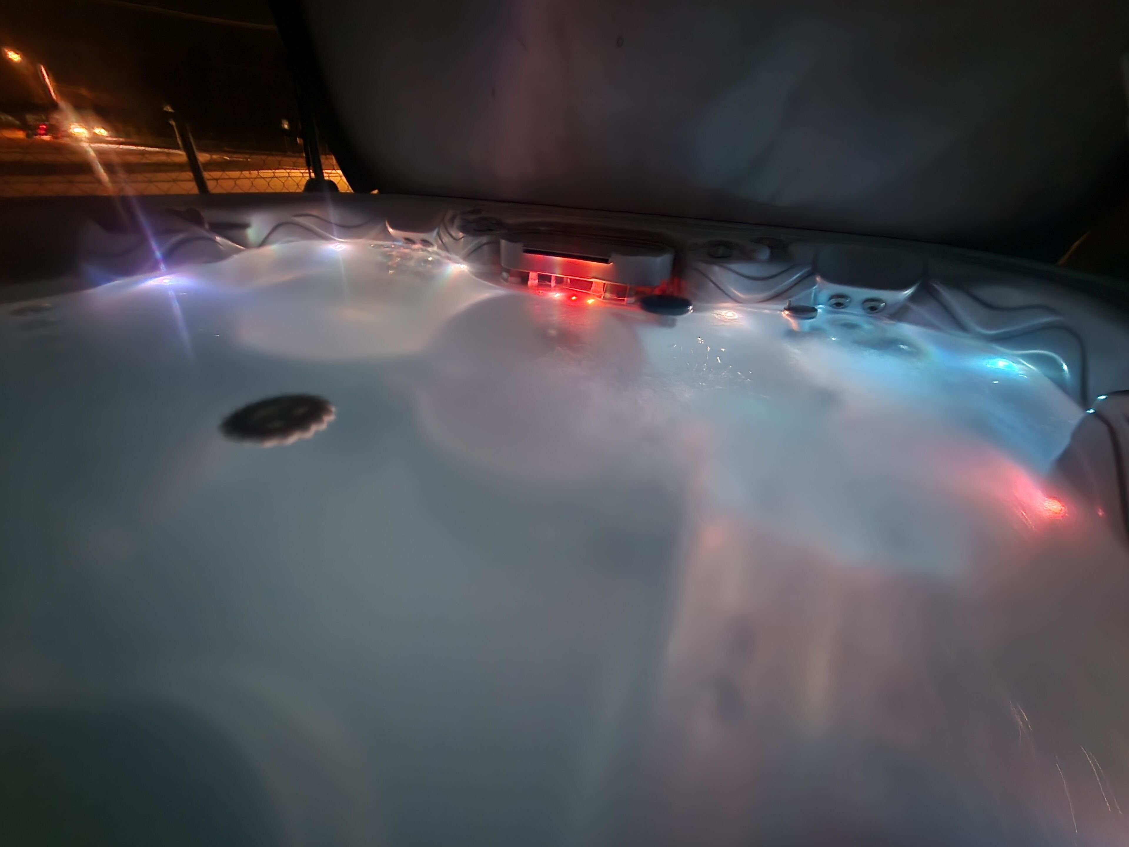Ein Whirlpool mit bunten Lichtern und sprudelndem Wasser.