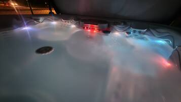 Ein Whirlpool mit bunten Lichtern und sprudelndem Wasser.