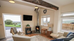 Una sala de estar acogedora con chimenea, asientos cómodos y vistas al exterior.