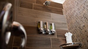 A bathroom with a shower, a towel rack, and a sink.
