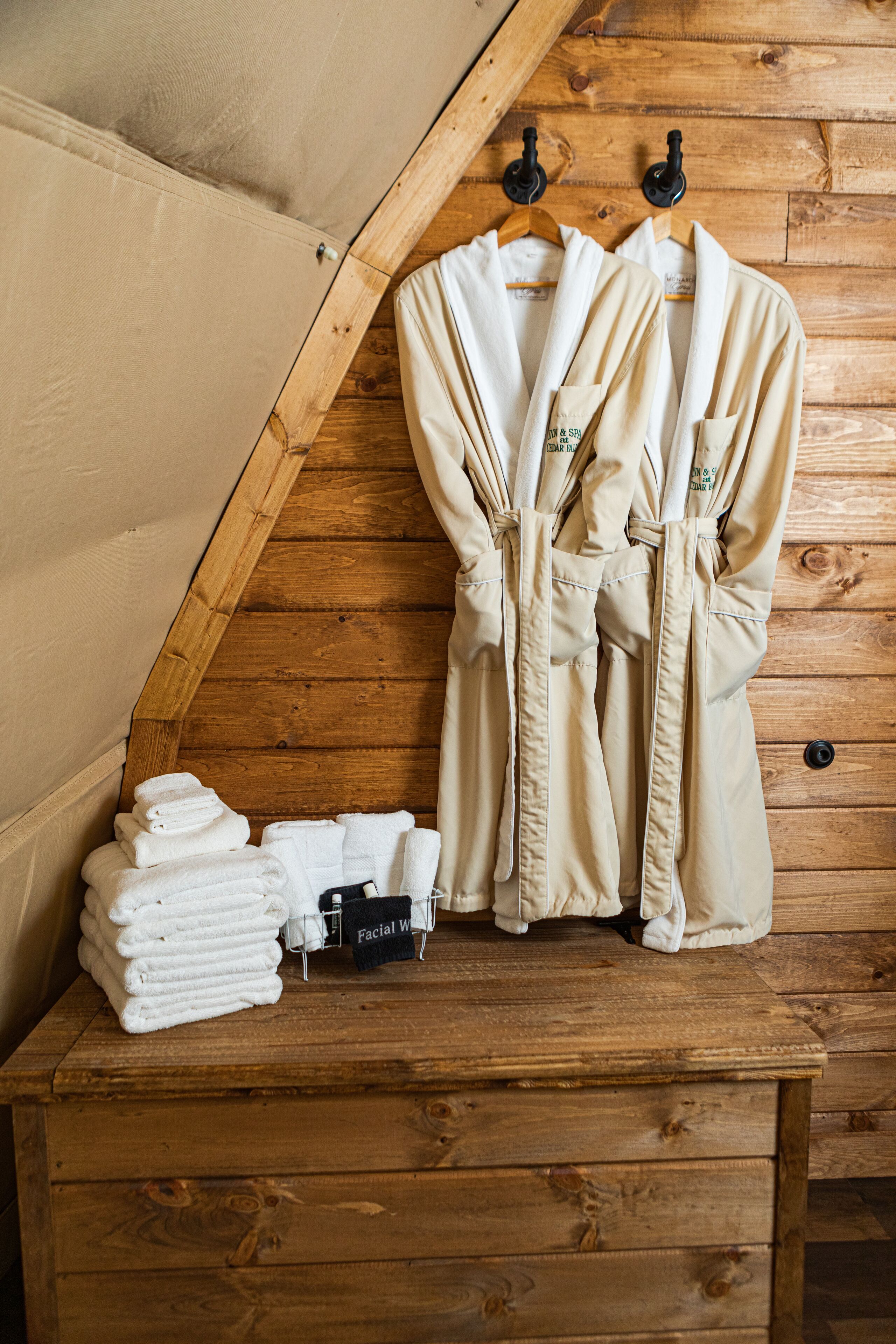 A wooden bench with towels and robes.