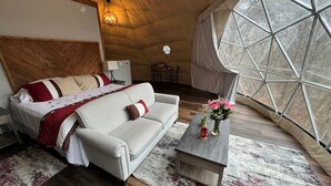 Une chambre confortable avec un lit, un canapé, une table basse et une grande fenêtre.