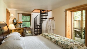 A bedroom with a large bed, a wooden staircase, a dresser, a mirror, and a view of the outdoors. - Tree House: Romantic Hocking Hills Cabin with King Bed, Soaking Tub and Free Breakfast (Logan)