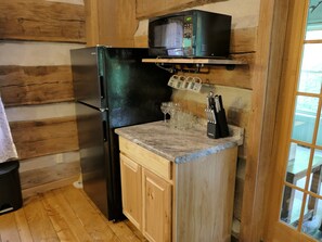 A compact kitchen with a black refrigerator, a microwave, and a wooden countertop. - Pine Grove: Dog-Friendly Hocking Hills Log Cabin with 2 Queen Bedrooms and Free Breakfast (Logan)