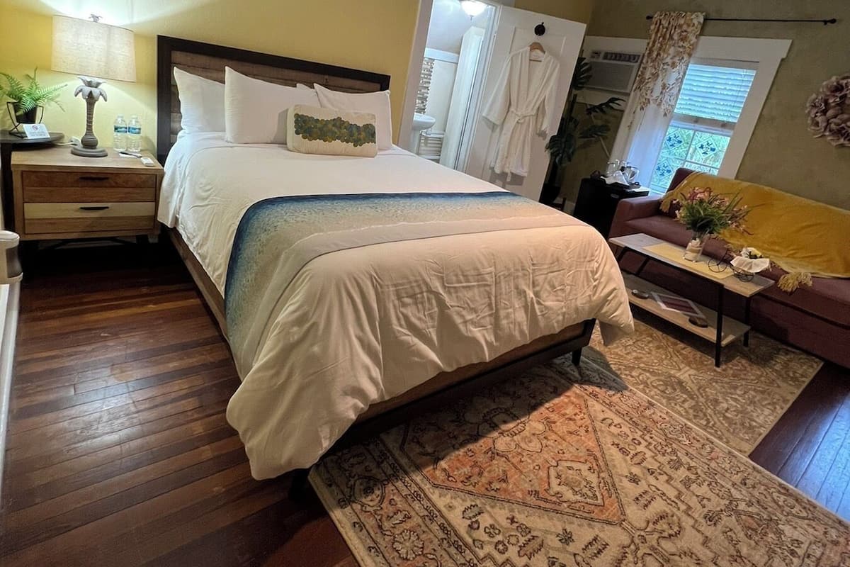 Une chambre à coucher comprenant un lit, une table de chevet et un ventilateur de plafond.