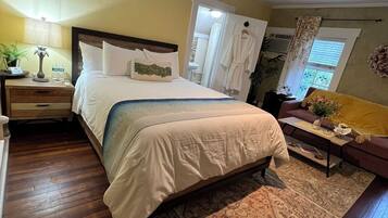 A bedroom with a bed, nightstand, bedside table, and a ceiling fan.