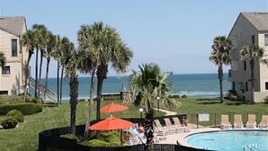 A beachfront hotel with a swimming pool, palm trees, and ocean views. - Summerhouse 433 (St. Augustine)