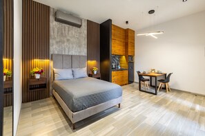 A modern bedroom with a bed, bedside tables, a desk, and chairs. - El Desierto by Naya Homes (San José del Cabo)