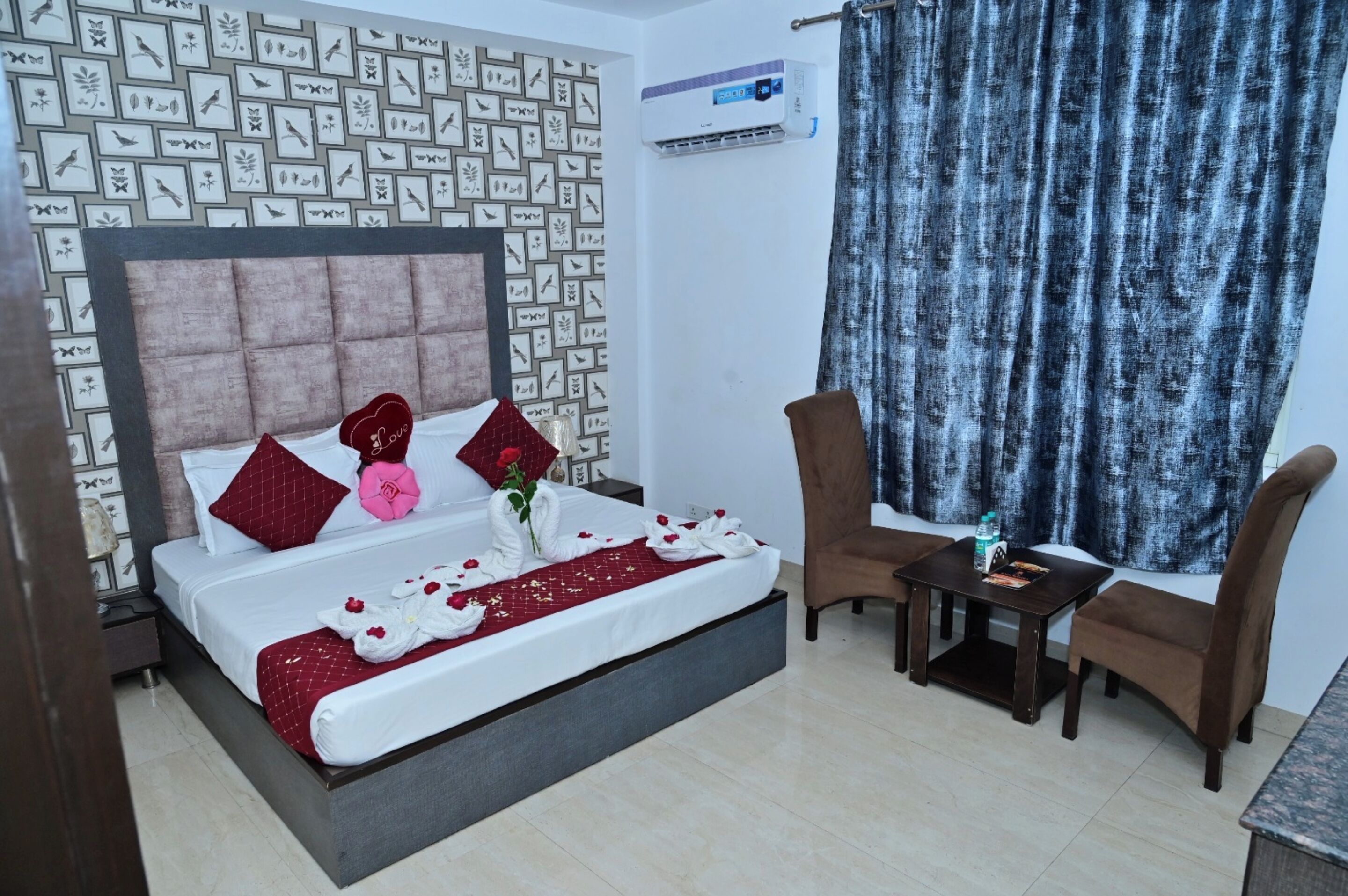 A neatly arranged bedroom with a bed, pillows, a bedside table, and a chair.