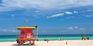 Na praia, espreguiçadeiras, toalhas de praia 