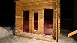 Une cabane en bois avec trois fenêtres et un sol recouvert de neige.