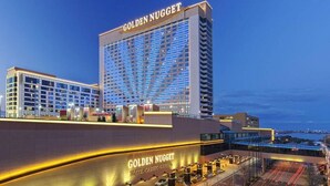 Ein Hotel mit auffälligem "Golden Nugget"-Schild, mehreren Etagen und moderner Architektur.