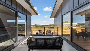 A modern interior with large glass windows, a central seating area with a woven chair, and a view of a rural landscape. - 1B Alpine View Retreat - 4BR Luxurious Escape l Mountain Views l Fast WiFi (Jindabyne)