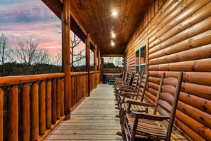 A wooden log cabin with a covered porch and several wooden benches. - New! Pet Friendly, Private Pool, Media Room, Golf! (Sevierville)