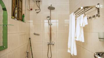 A bathroom with a shower, toilet, and towel rack.