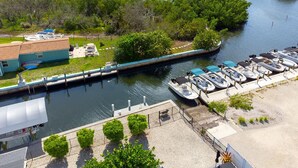 A marina with boats docked, a grassy area with a building, and a waterway with islands.