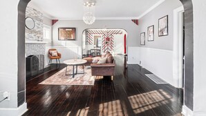 A modern living room with a fireplace, a round table, and a sofa. - 15 mins to beach/Renew+Relax/Clean/ Nat’l Park!/Theater/Game Room/Pet Friendly (Gary)