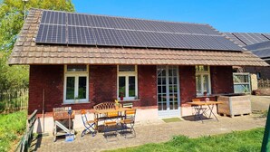 Una casa con techo de tejas, paneles solares y fachada de ladrillo.
