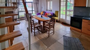 Una cocina amplia con comedor, una escalera y un ventanal grande.