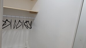 Een kast met houten planken en een kledingroede.