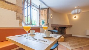 A breakfast table with two glasses of orange juice, a cup, and a plate. - Hotel Bestprice Santillana  (Santillana del Mar)