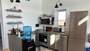 Una cocina moderna con electrodomésticos de acero inoxidable, un dispensador de agua y un horno empotrado.