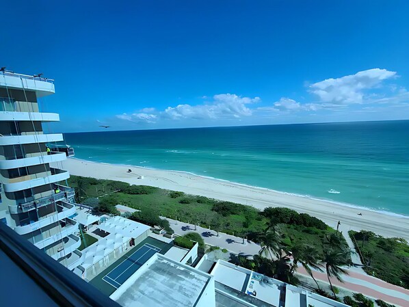 A high-rise building with multiple balconies overlooking a beach. - OCEANVIEW Condo King size bed with free parking (Miami)