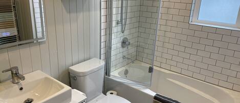 A bathroom with a toilet, sink, and bathtub.