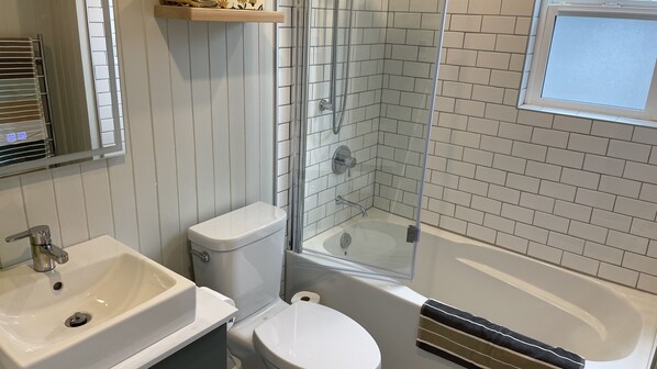 A bathroom with a toilet, sink, and bathtub.