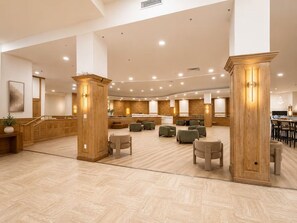 A spacious lobby with a reception desk, seating area, and wooden pillars. - BEACHFRONT CONDO-HOTEL bayview with free parking (Miami)