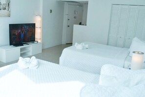 A hotel room with two beds, a TV, a bedside table, and a wardrobe. - BEACHFRONT CONDO-HOTEL bayview with free parking (Miami)