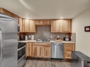 Una cocina moderna con armarios de madera, electrodomésticos de acero inoxidable y lavavajillas.