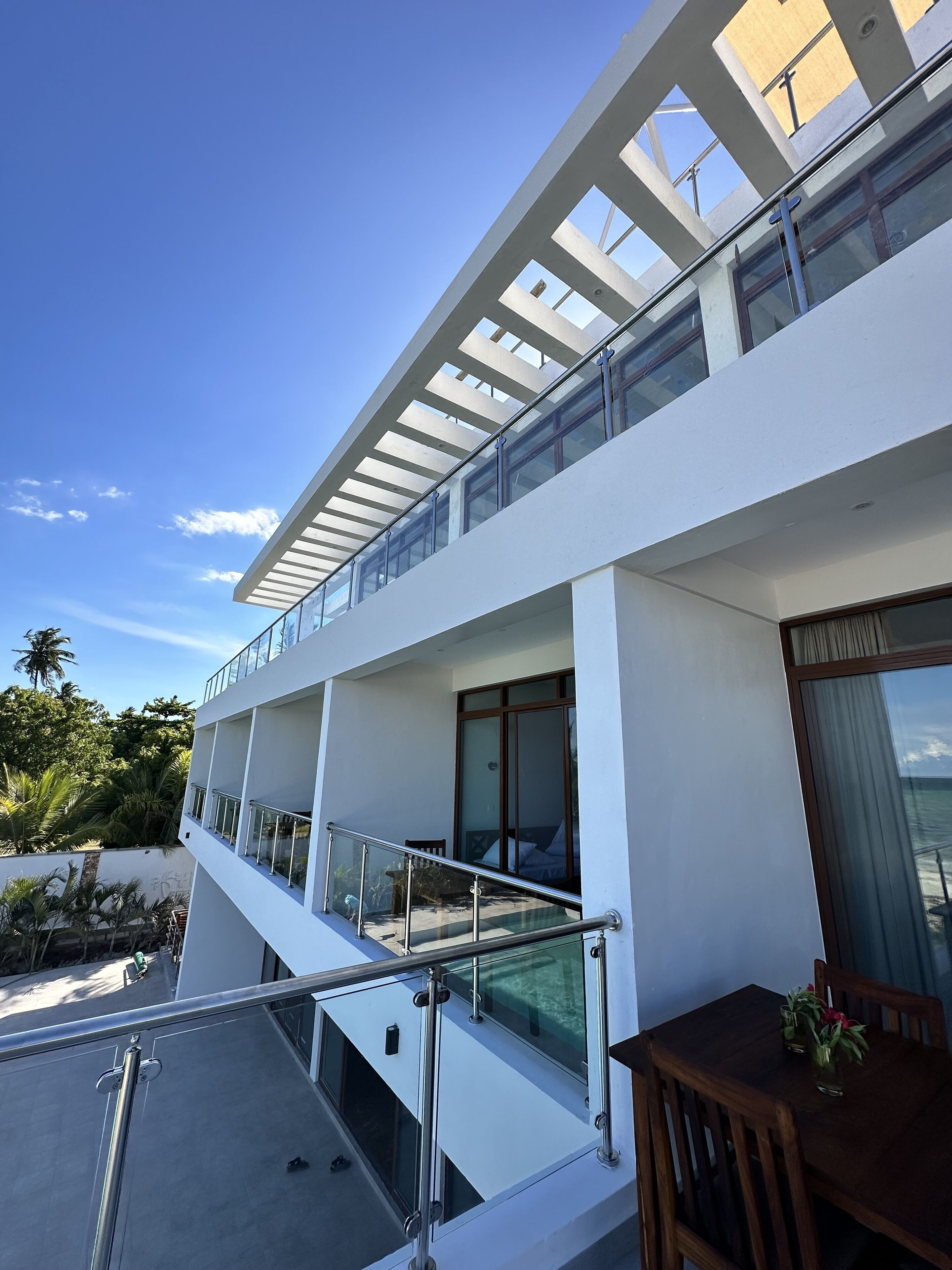 Un edificio moderno de varios pisos, con balcones, ventanas amplias y una vista despejada del cielo.