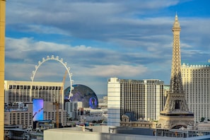 A cityscape with a Ferris wheel, the Eiffel Tower, and modern buildings. - Vdara Hotel & Spa Private Residences (Las Vegas)