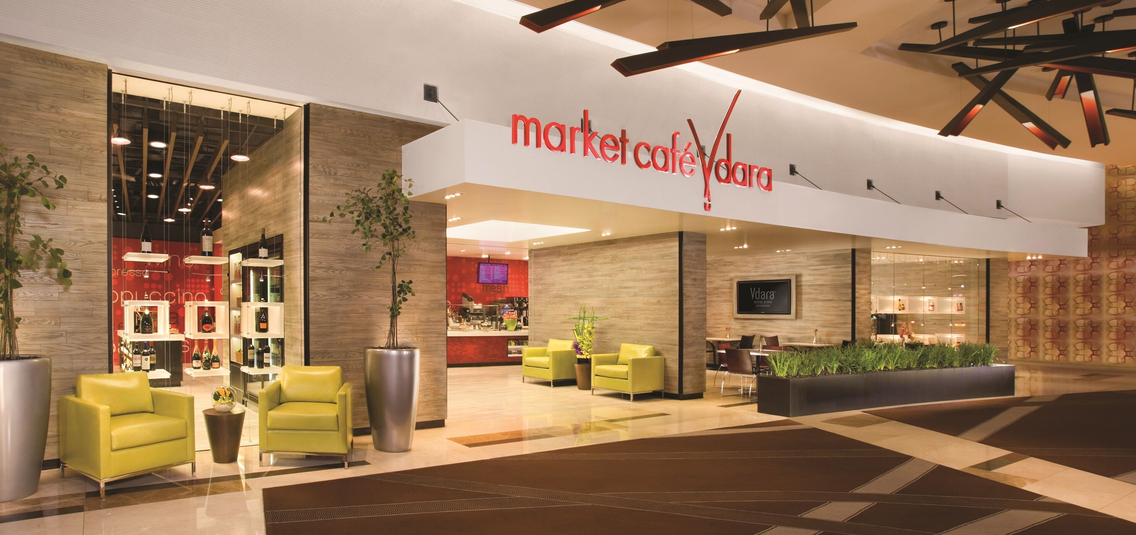 Ein modernes Interieur mit einer Sitzecke, einer Bar und einem sichtbaren Schaufenster mit der Aufschrift "market café Vdara".