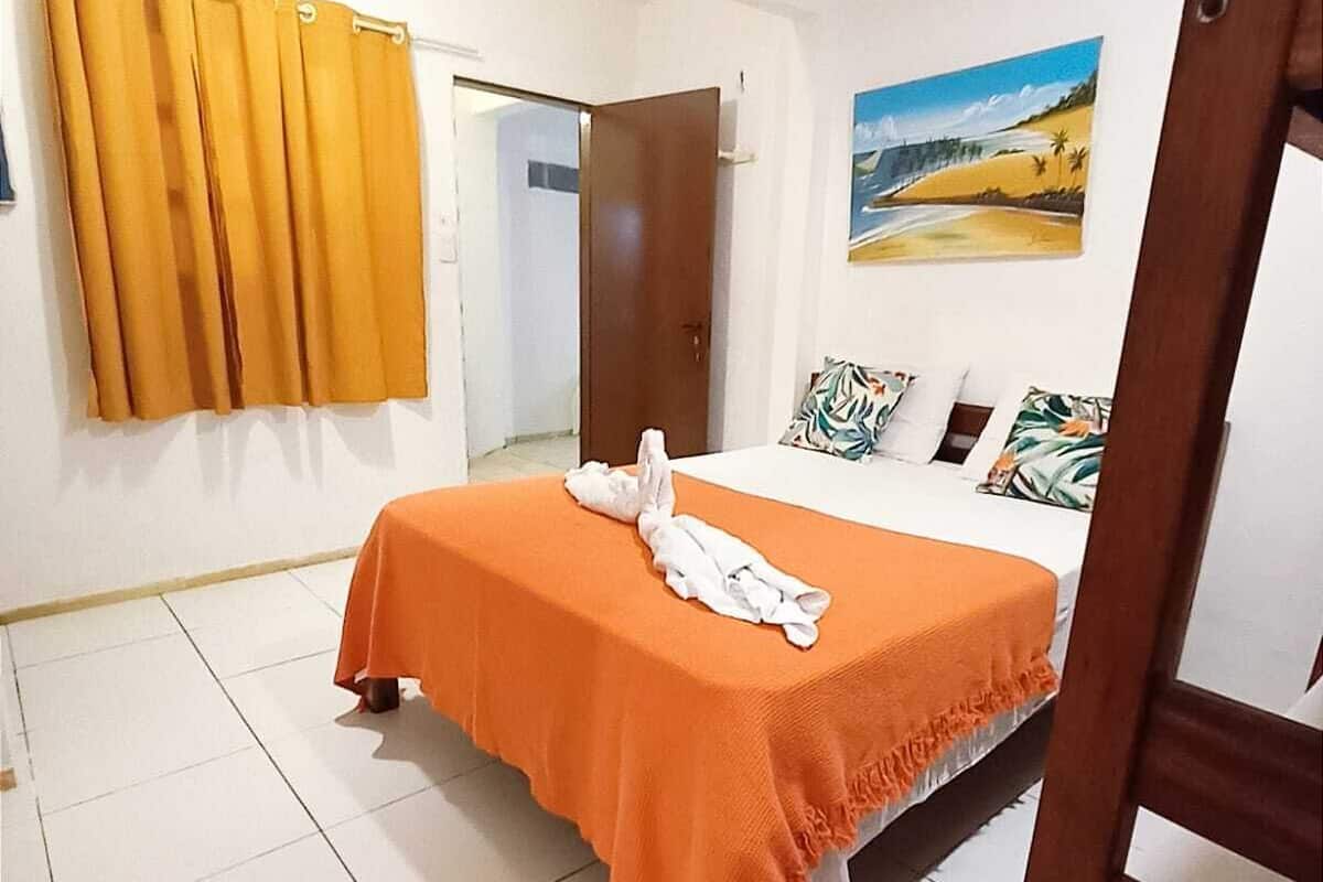 Ein Schlafzimmer mit einem Bett, einem Bild an der Wand und einer Tür zu einem anderen Raum.