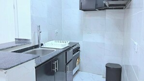 A compact kitchen with a sink, stove, and cabinets.