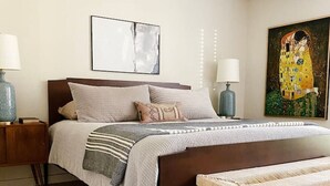 A bedroom with a bed, bedside tables, a ceiling fan, a painting, and a rug. - Fireplace, Fire Pit, Turf Backyard | Central ATX (Austin)