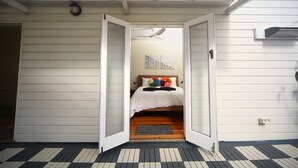 Una habitación con cama, ventilador de techo y ventana.