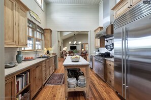 Enjoy cooking in this well-lit kitchen with a central island, refrigerator, and dining area nearby.