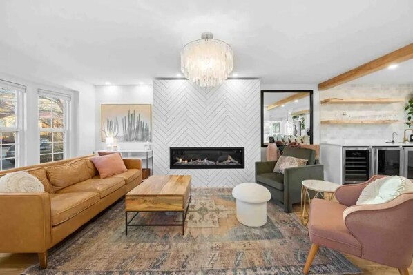 A modern living room with a fireplace, a herringbone-patterned wall, and a large window. - Beautiful modern home in Arvada (Arvada)