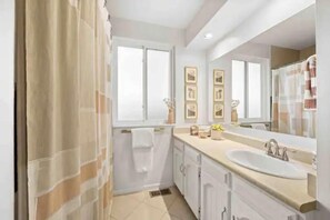 A modern bathroom with a large sink, a mirror, and framed pictures on the wall. - Beautiful modern home in Arvada (Arvada)